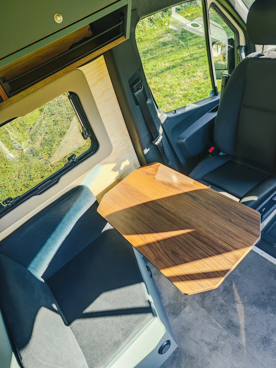 espace-repas-xplorer-van-4×4 Espace repas table avec pied Lagun en fourgon aménagé Mercedes Sprinter 4x4 haut de gamme - Wood and van aménageur de fourgon à Nantes